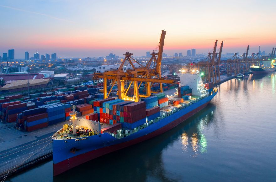 Container port at dusk, a ship being loaded under cranes