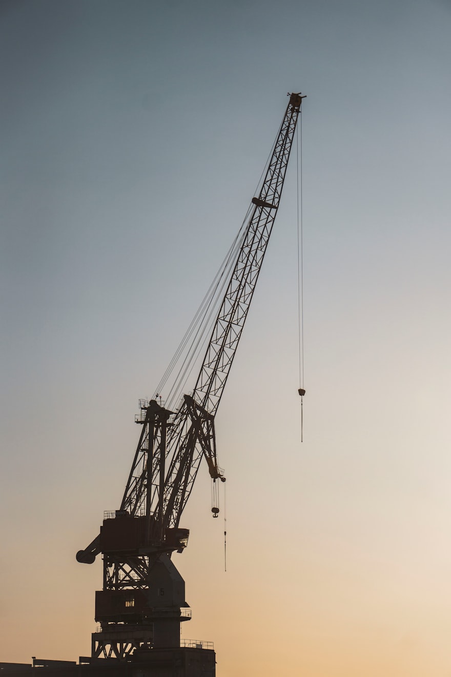 Harbour crane silhouetted against a dusk sky